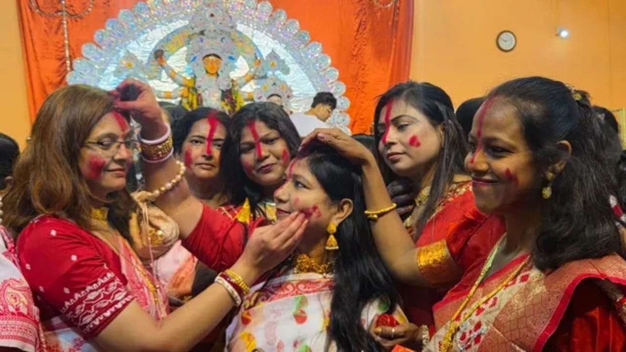 हरि मंदिर में सिंदूर खेला में एक-दूसरे को सिंदूर लगातीं महिलाएं।